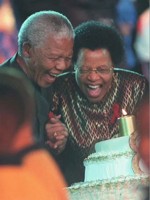 South African Preisdent Nelson Mandela, left, blows out the candles on his birthday cake with his new wife, Graca Machel at a glittering reception held at Gallagher Estate outside Johannesburg, Sunday July 19, 1998. (Photo by Walter Dhdladla/AP Photo)