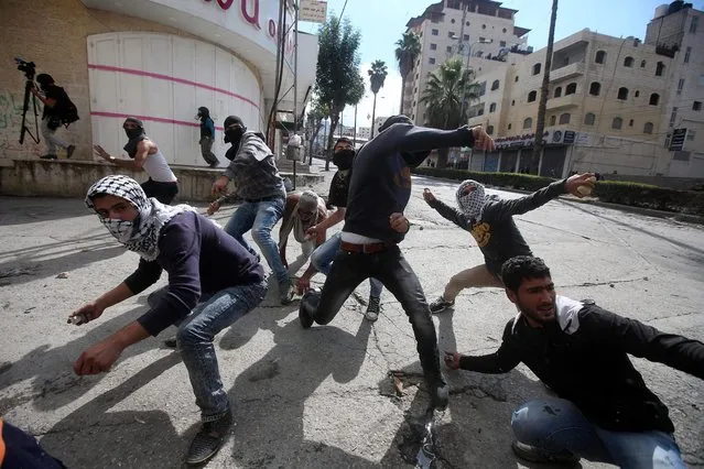 Palestinian protesters throw stones at Israeli soldiers during clashes in the West Bank of Hebron, 30 October 2015. Since the start of October, violence that has included stabbings as well as clashes between Palestinian protesters and Israeli security forces has killed at least 65 Palestinians and 10 Israelis. (Photo by Abed Al Hashlamoun/EPA)