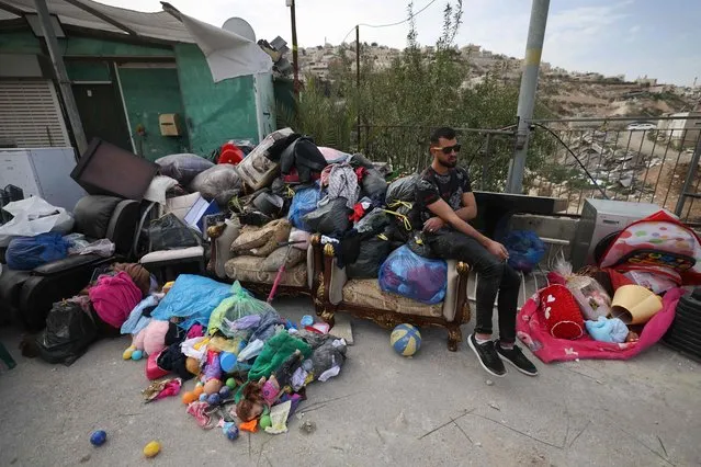 A Palestinian man sits next to the belongings of Rateb Hatab Shukairat, after the house was demolished by Israeli bulldozers, in the East Jerusalem neighbourhood of Jabal Mukaber on January 29, 2023. (Photo by Ahmad Gharabli/AFP Photo)
