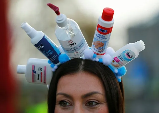 A carnival reveller wears a hat made of disinfection bottles as the traditional celebrations of the start of the famous Cologne carnival season is officially cancelled due to the spread of the coronavirus disease (COVID-19) in Cologne, Germany, November 11, 2020. (Photo by Thilo Schmuelgen/Reuters)