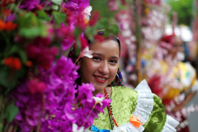 A woman holds a palm with flowers prior to a procession during the celebration of the Palms and Flowers Festival in Panchimalco, El Salvador on May 5, 2024. (Photo by Jose Cabezas/Reuters)