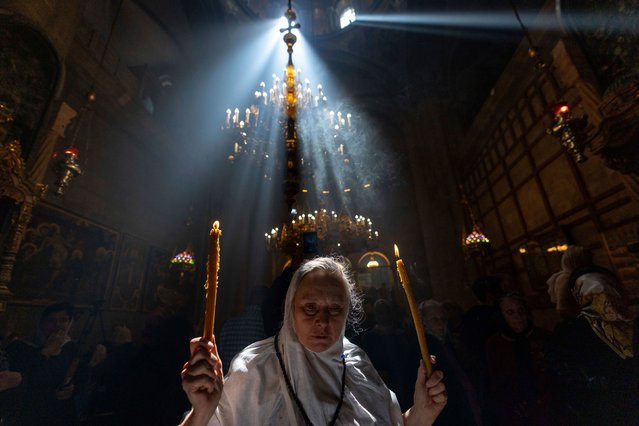 A Christian pilgrim holds candles as people gather during the ceremony of the Holy Fire at the Church of the Holy Sepulchre, in Jerusalem's Old City, on Saturday, May 4, 2024. (Photo by Ohad Zwigenberg/AP Photo)