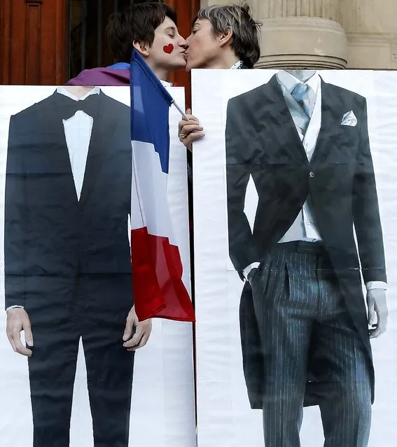 Pro-gay marriage activists pose on April 23, 2013, during a gathering at Paris 4th district city hall after French lawmakers legalized same-s*x marriage. France's justice minister, Christiane Taubira, said the first weddings could be as soon as June. (Photo by Francois Mori/Associated Press)