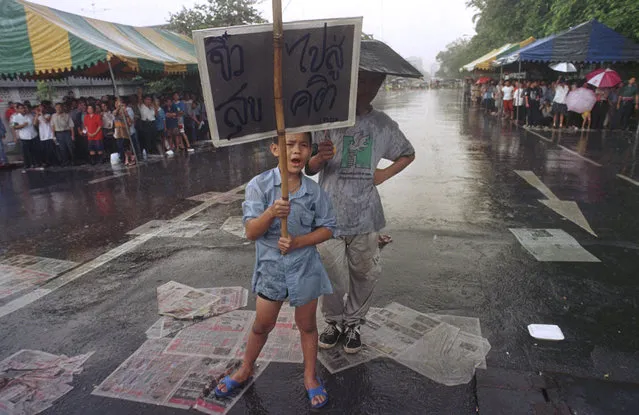 In this October 23, 1997, file photo, a boy calls for the resignation of Prime Minster Chavalit Youngchaiyudh for the poor handling of the Asian financial crisis outside the Government House in Bangkok. (Photo by Sakchai Lalit/AP Photo)