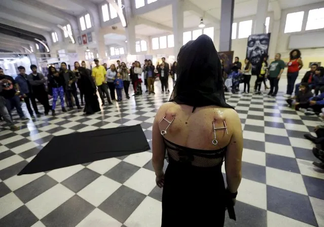 A woman with hooks pierced into her skin waits to be suspended during a latin america convention of tattoo and suspension in Valparaiso city November 8, 2015. (Photo by Rodrigo Garrido/Reuters)