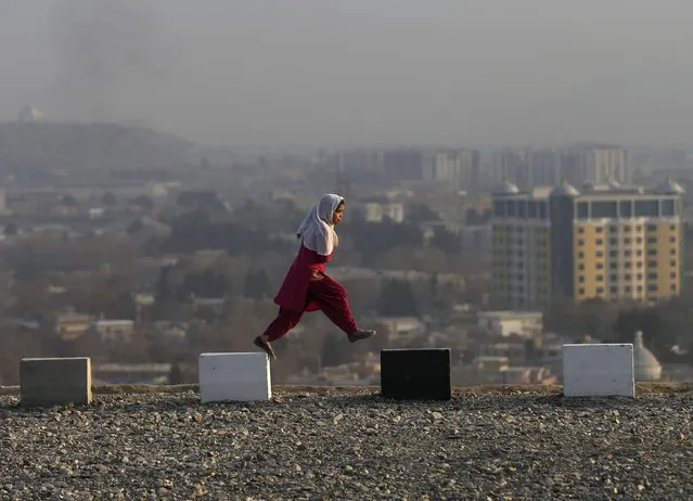 An Afghan girl walks on a hilltop overlooking Kabul December 21, 2014. (Photo by Mohammad Ismail/Reuters)
