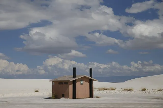 A toilet block is surrounded by white sand in the White Sands National Monument park area near Alamogordo, New Mexico, United States, October 6, 2015. The park's white sand dunes are composed of gypsum crystals. It is the largest gypsum dune field in the world. (Photo by Shannon Stapleton/Reuters)