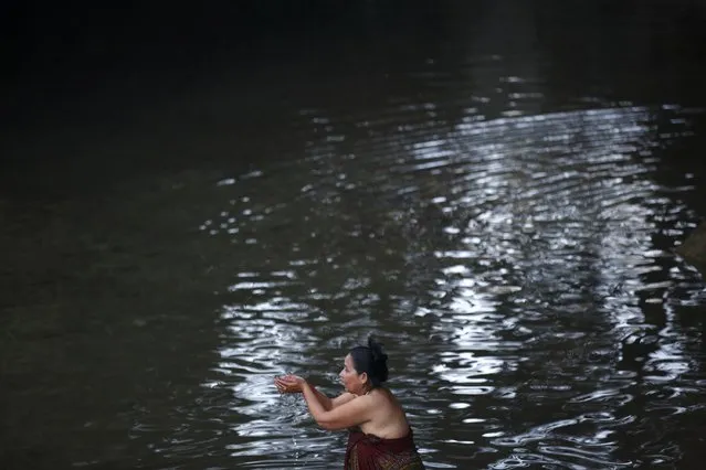 A devotee takes a holy bath in River Saali in Sankhu on the first day of Swasthani Brata Katha festival in Kathmandu January 5, 2015. (Photo by Navesh Chitrakar/Reuters)