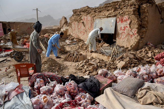 Afghan shopkeepers search for remains of their damaged shops along a highway, following an earthquake at the Tang-e Tashkurgan in the Khulm district of Samangan province on November 3, 2025. (Photo by Atif Aryan/AFP Photo)