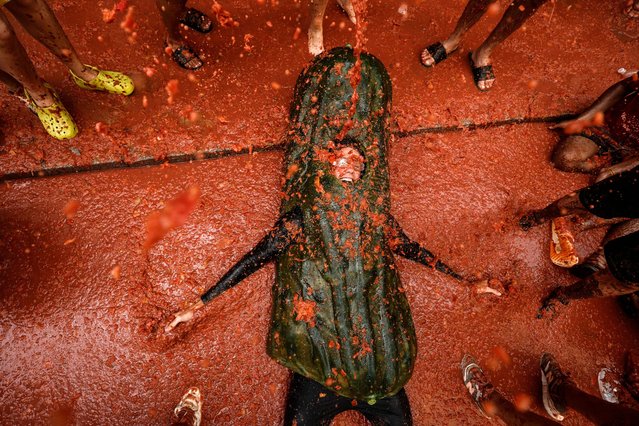People attend the traditional Tomatina festival in Buñol, Spain on August 29, 2024. Every year on the last Wednesday of August, thousands of people visit the village for the Tomatina, a battle in which participants throw tons of overripe tomatoes at one another. (Photo by Biel Alino/EPA/EFE/Rex Features/Shutterstock)