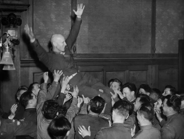 Gen. Wiulliam H. Simpson of the U.S. Ninth Army smiles broadly and waves his arms as he is tossed by Russian officers at a banquet in his honor on Russian held territory in Germany on May 18, 1945. Col. Gen. Sviataiev, commander of the 33rd Russian Army was host. Gen. Simpson was tossed three times by Russians in whose country it is a sign of great honor. (Photo by AP Photo)