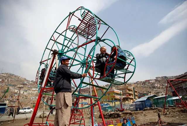 Children enjoy a manually operated ferris wheel in Kabul, Afghanistan March 20, 2018. (Photo by Mohammad Ismail/Reuters)