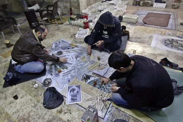 Men work on a mosaic artwork, copied from an original painting, in a workshop in Kafranbel town in the Idlib governorate January 17, 2015. (Photo by Khalil Ashawi/Reuters)