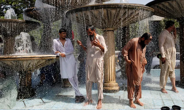 Men cool off from the heatwave, as they shower at a water fountain along a road in Karachi, Pakistan May 25, 2018. (Photo by Akhtar Soomro/Reuters)