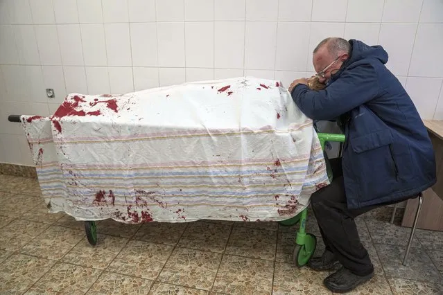Serhii, father of teenager Iliya, cries on his son's lifeless body lying on a stretcher at a maternity hospital converted into a medical ward in Mariupol, Ukraine, Wednesday, March 2, 2022. (Photo by Evgeniy Maloletka/AP Photo)