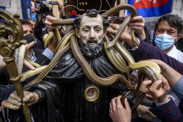 Snake catchers (Serpari) put their snakes on the patron Saint's statue (Saint Domenico) during the annual religious procession on May 1, 2022 in Cocullo, Italy. The Festival of Snake catchers (Festa dei Serpari) is an annual religious procession during which the patron Saint's statue (Saint Domenico) is carried covered with living snakes. The festival of Snake catchers resumed after a hiatus due to the Covid-19 Pandemic. (Photo by Antonio Masiello/Getty Images)