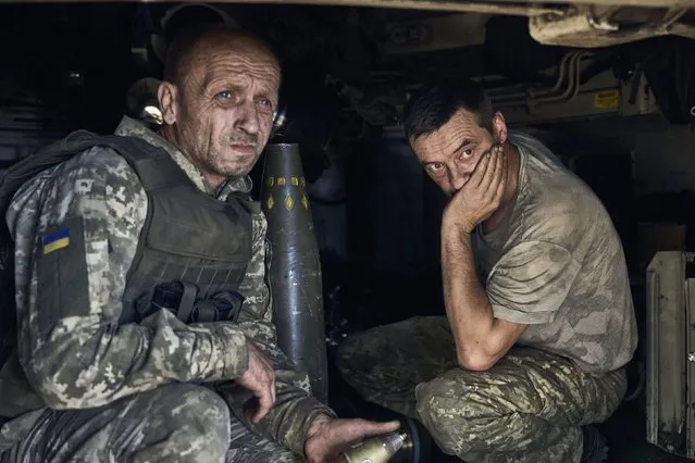 Ukrainian soldiers sit inside self-propelled howitzer at the front line in Donetsk region, Ukraine, Wednesday, August 9, 2023. (Photo by Libkos/AP Photo)