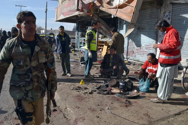 Pakistani police officer and rescue workers gather at the site of suicide bombing in Quetta, Pakistan, Wednesday, January 13, 2016. The suicide attack on a polio vaccination center in southwestern Pakistan killed more than a dozen people and wounded many, officials said. (Photo by Arshad Butt/AP Photo)