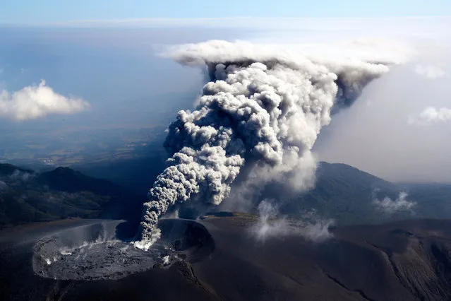 In this aerial image, volcanic ash spews from the crater of Mt. Shinmoedake on October 11, 2017 in Kirishima, Kagoshima, Japan. The eruption sends a plume of ash 300 meters into the air. The volcano, part of the Kirishima range in southern Kyushu, straddles the border of Miyazaki and Kagoshima prefectures. It previously erupted September 7, 2011. (Photo by The Asahi Shimbun via Getty Images)