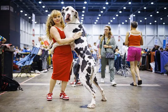 A woman poses with her dog during the World Dog Show 2023 competiton in Geneva, Switzerland, 26 August 2023. Participants from 80 countries are presenting over 21,500 dogs from 350 breeds to a pannel of 160 judges during five days of competition. (Photo by Valentin Flauraud/EPA)