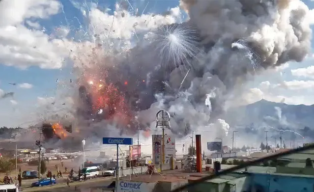 A massive explosion guts Mexico's biggest fireworks market in Tultepec, on December 20, 2016. The explosion killed at least 31 people and injured 72, authorities said. The conflagration in the Mexico City suburb of Tultepec set off a quick-fire series of multicolored blasts that sent a vast cloud of smoke billowing over the capital. (Photo by Jose Luis Tolentino/AFP Photo)