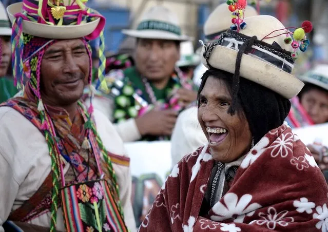 Indigenous people joke during the Anata Andina (Andean carnival) parade in Oruro, February 4, 2016. Hundreds of ethnic groups from Oruro province participated in the carnival. (Photo by David Mercado/Reuters)