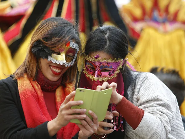 Two masked tourists use a mobile device during carnival celebrations in Valletta, Malta, February 7, 2016. (Photo by Darrin Zammit Lupi/Reuters)