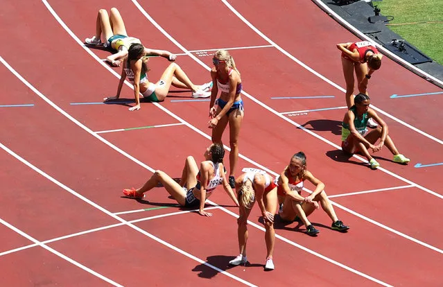 Athletes react after completing heat three of the women's 3,000-meter steeplechase at Olympic Stadium in Tokyo, Japan on August 1, 2021. (Photo by Phil Noble/Reuters)