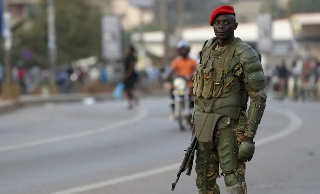 A soldier holds his weapon as he watches a procession by Uganda's leading opposition party Forum for Democratic Change supporters being dispersed in Kampala, Uganda, February 15, 2016. (Photo by James Akena/Reuters)