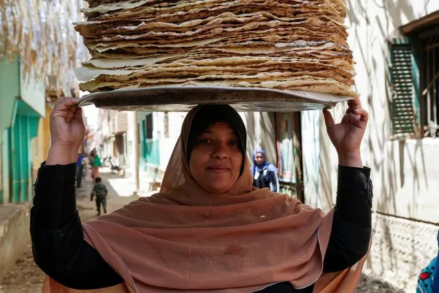 Nour El-Sabah, 35, carries bread and poses for the camera during the holy month of Ramadan in Beni Suef, Egypt, April 10, 2021. (Photo by Hayam Adel/Reuters)