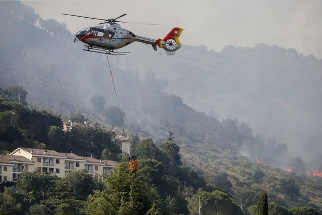 Emergency staff fights a fire on Castillo mountain park near Tivoli a few miles from Rome, Italy, Friday, August 13, 2021. Intense heat baking Italy pushed northward towards the popular tourist destination of Florence Friday while wildfires charred the country's south, and Spain appeared headed for an all-time record high temperature as a heat wave kept southern Europe in a fiery hold. (Photo by Cecilia Fabiano/LaPresse via AP Photo)