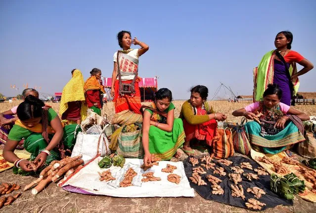 Women belonging to the Tiwa tribe display their merchandise as they wait to exchange them with the locals through a barter system as part of celebrations for the Assamese festival of Magh Bihu at Dharamtul area, in Morigaon district, in the northeastern state of Assam, India January 16, 2017. (Photo by Anuwar Hazarika/Reuters)