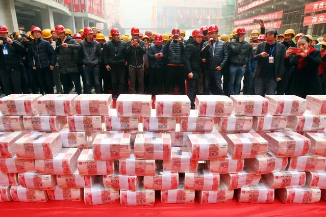 Migrant workers wait to collect their salary and bonus ahead of the Spring Festival at a construction site in Xi'an, Shaanxi province, China, Janauary 18, 2017. (Photo by Reuters/Stringer)