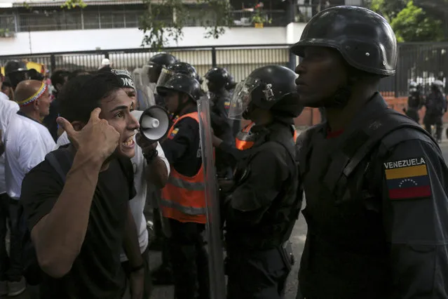 A demonstrator rants at a Venezuelan National Police officer who temporarily blocks members of the opposition from reaching a rally against the government of President Nicolas Maduro in Caracas, Venezuela, Saturday, March 9, 2019. (Photo by Fernando Llano/AP Photo)