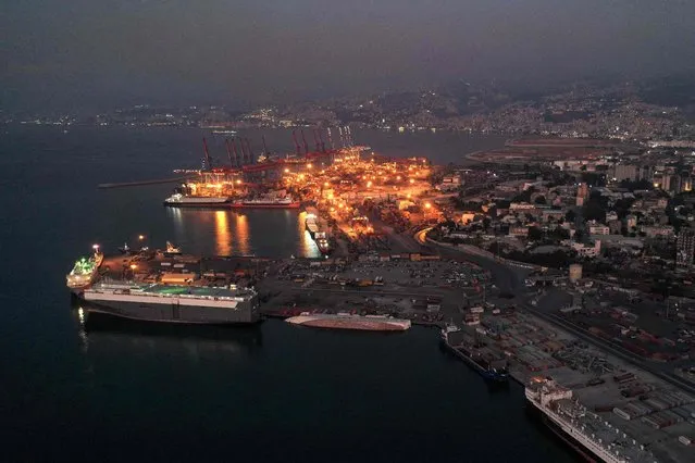 This picture taken on October 11, 2021 shows a sunset aerial view of the devastated port of Lebanon's capital Beirut, in darkness during a power outage. (Photo by AFP Photo/Stringer)