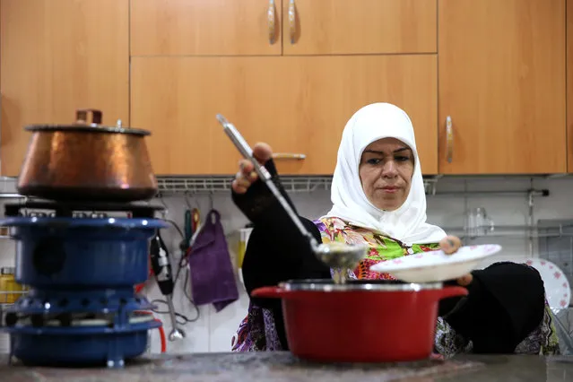 In this picture taken on Thursday, January 28, 2015, Zohreh Etezadossaltaneh ladles soup into a bowl for lunch at her home, in Tehran, Iran. (Photo by Ebrahim Noroozi/AP Photo)