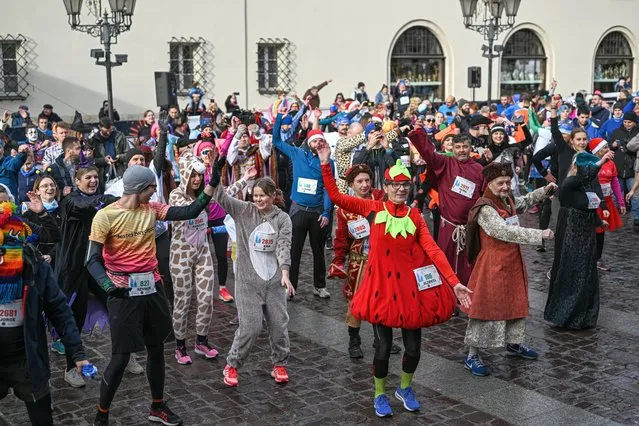 Hundreds of people warm up while dressed in funny clothing as they take part in the 18th Krakow New Year's Eve Run at the Small Square in Krakow, Poland on December 31, 2022. For 18 years, Krakow holds a satirical New year's eve run, where hundreds of citizens come dressed in funny clothing and run on two different distance races around the old city. (Photo by Omar Marques/Anadolu Agency via Getty Images)