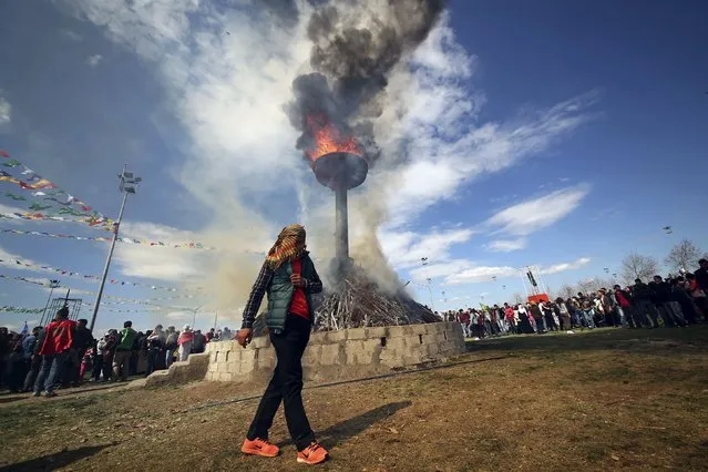 A masked demonstrator walks around a bonfire during a gathering to celebrate the spring festival of Newroz in the Kurdish-dominated southeastern city of Diyarbakir, Turkey March 21, 2016. Turkey's Kurds on Monday marked the annual spring festival of Newroz with a call for the resumption of peace talks between the government and Kurdish militants, but four Turkish soldiers were killed in another rebel attack in the restive southeast region. (Photo by Sertac Kayar/Reuters)