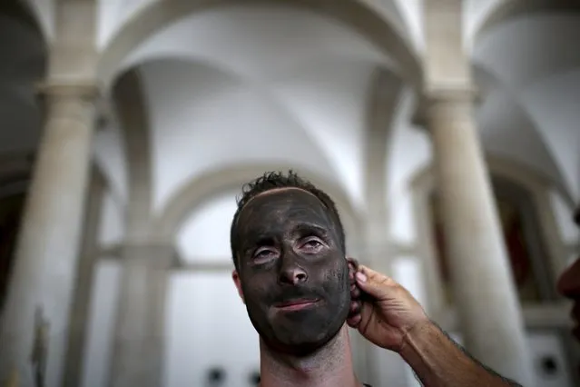 A masked man is painted before the parade of the 10th International Festival of the Iberian Mask in Lisbon, Portugal May 9, 2015. (Photo by Rafael Marchante/Reuters)