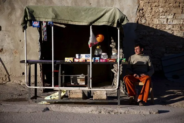 A street vendors sits near his stall in the rebel held Douma neighborhood of Damascus, Syria March 20, 2016. (Photo by Bassam Khabieh/Reuters)