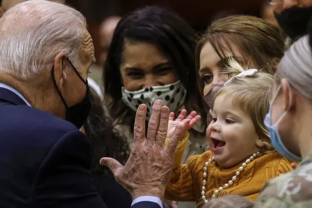 U.S. President Joe Biden high fives 16-month-old Breklyn Petroelje as he gathers with U.S. service members and military families during a Thanksgiving event at Fort Bragg, North Carolina, U.S., November 22, 2021. (Photo by Leah Millis/Reuters)
