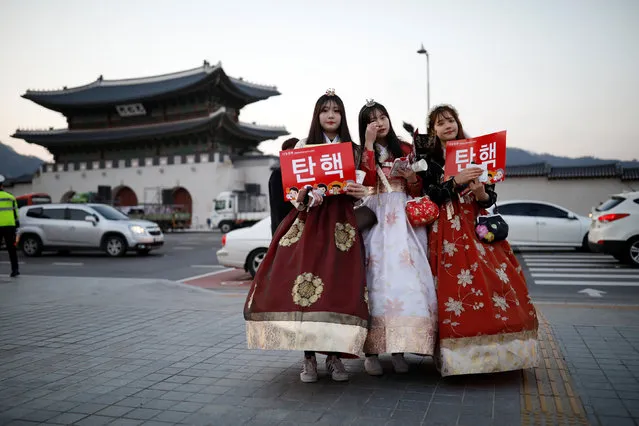 Women wearing a Korean traditional costume Hanbok attend a protest demanding South Korean President Park Geun-hye's resignation on the occasion of the fourth anniversary of her inauguration, in Seoul, South Korea, February 25, 2017. The sign reads “Impeachment”. (Photo by Kim Hong-Ji/Reuters)