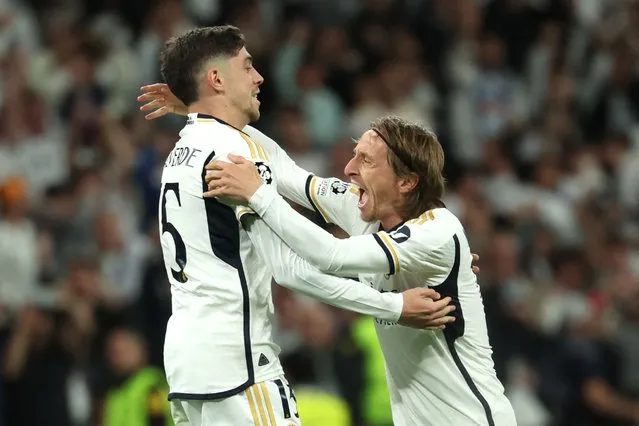 Real Madrid's Uruguayan midfielder #15 Federico Valverde celebrates scoring his team's third goal with Real Madrid's Croatian midfielder #10 Luka Modric during the UEFA Champions League quarter final first leg football match between Real Madrid CF and Manchester City at the Santiago Bernabeu stadium in Madrid on April 9, 2024. (Photo by Pierre-Philippe Marcou/AFP Photo)
