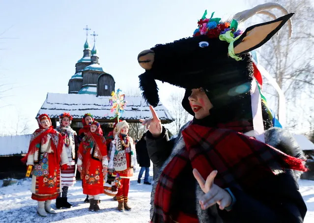 People dressed in traditional costumes sing Christmas carols as they gather to celebrate Orthodox Christmas at a compound of the National Architecture museum in Kyiv, Ukraine on January 7, 2022. (Photo by Valentyn Ogirenko/Reuters)