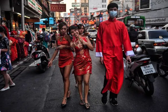 People wear traditional Chinese outfits as they walk in Chinatown in Bangkok on February 11, 2021, ahead of the start of the Lunar New Year, which ushers in the Year of the Ox on February 12. (Photo by Lillian Suwanrumpha/AFP Photo)