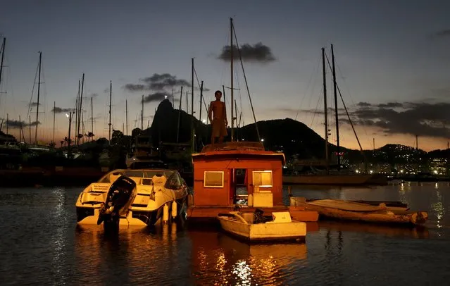 Naval carpenter Alexandro de Oliveira, 41, stands atop his boat house in the waters of the Guanabara Bay in Rio de Janeiro Brazil, April 5, 2016. (Photo by Ricardo Moraes/Reuters)