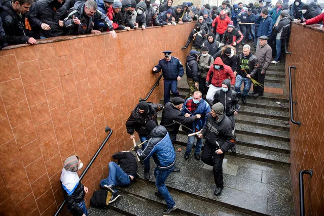 Pro-Russia supporters beat a pro-Western activist who lies on the stairs  during a pro Russian rally in Kharkiv, Ukraine, Sunday, April 13, 2014. Two rival rallies in Kharkiv turned violent after a group of pro-Russian protesters followed several pro-Ukrainian activists, beating them with baseball bats and sticks. (Photo by Olga Ivashchenko/AP Photo)