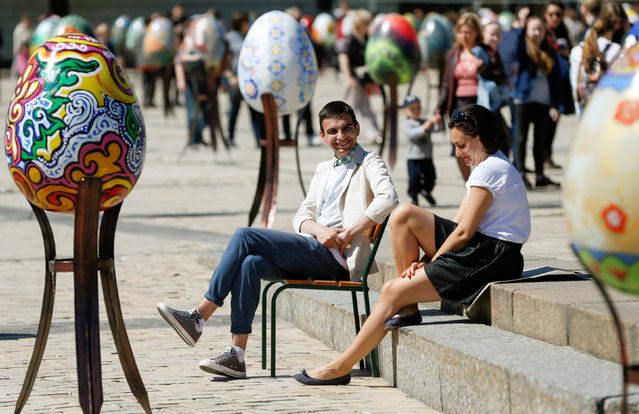 People sit near traditional Ukrainian Easter eggs “Pysanka”, installed as part of the upcoming celebrations of Easter, in central Kiev, Ukraine, April 29, 2016. (Photo by Valentyn Ogirenko/Reuters)