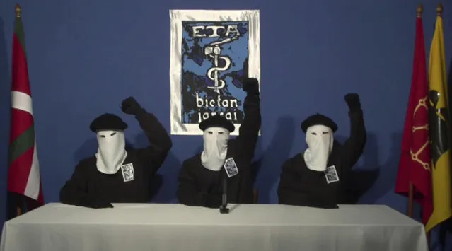 In this file image made from video provided on Oct. 20, 2011, masked members of the Basque separatist group ETA hold up their fists in unison following a news conference at an unknown location. Spanish media are reporting that ETA are set to announce Friday March 17, 2017 its new initiative to lay down weapons aimed at speeding the stalled process of disbanding. (Photo by Gara via AP Photo)