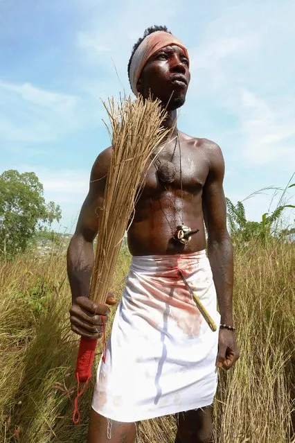 A Soko Bana Poro society member prepares in Waterloo, Sierra Leone on November 25, 2018 for a ritual performance. The broom in his hand is used to control the healing power that comes thru the air from his spiritual gods to heal the wound in his stomach. (Photo by Lynn Rossi/AFP Photo)